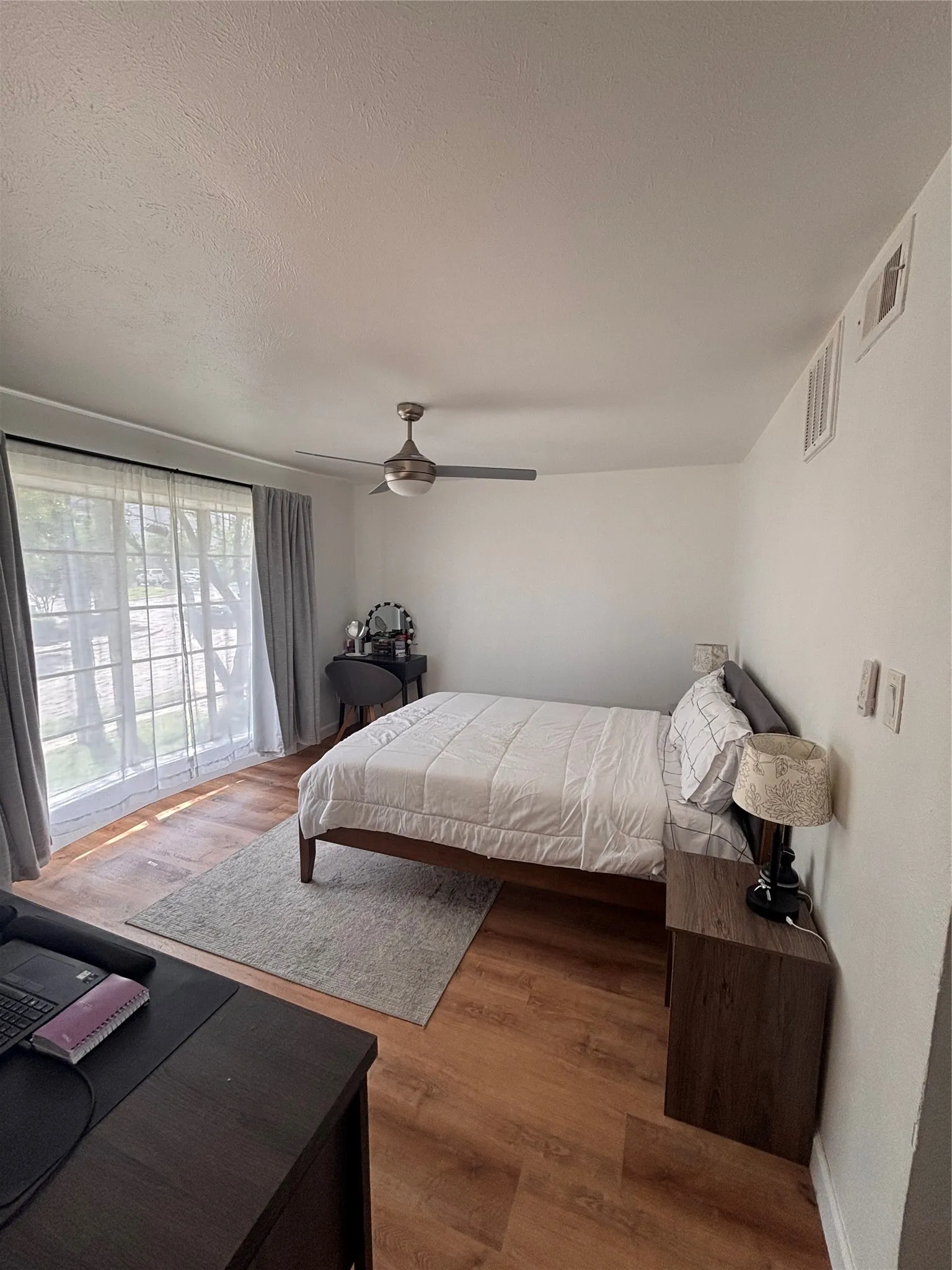 Bright room featuring wood-finish flooring and a ceiling fan