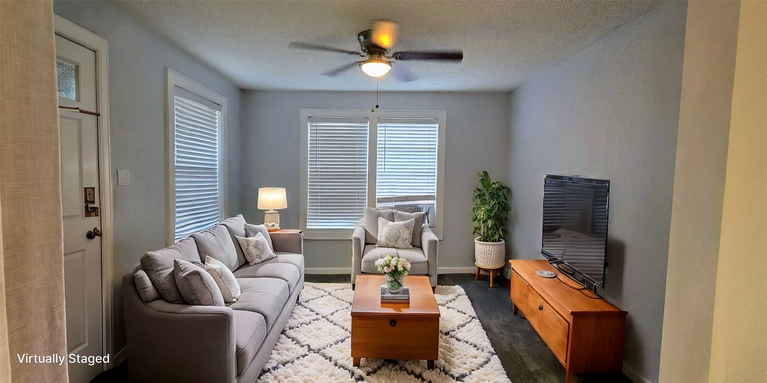 Living room featuring ceiling fan and a textured ceiling