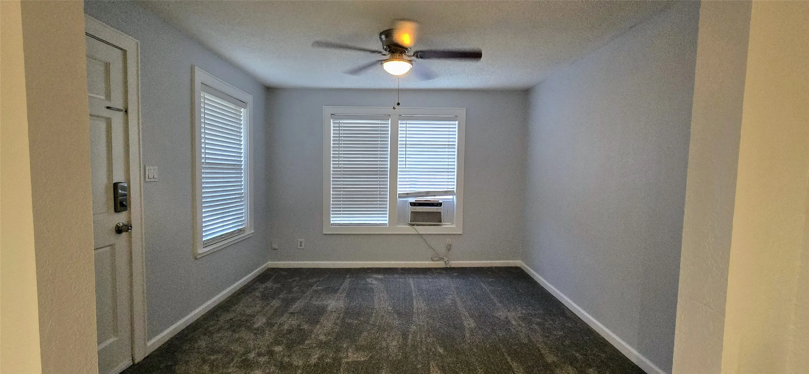 Carpeted spare room featuring ceiling fan