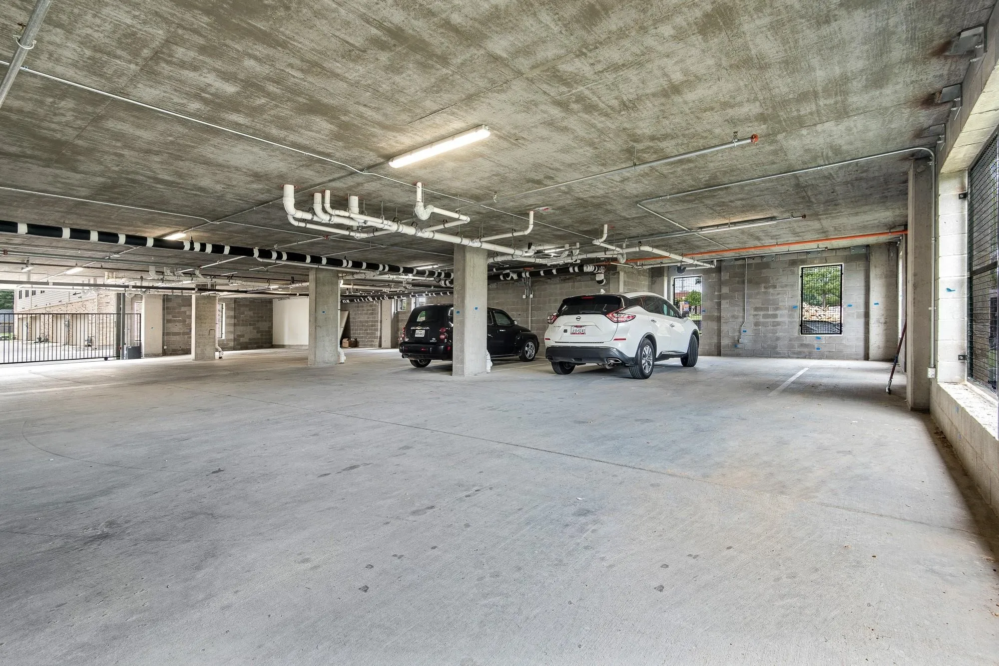The property features a concrete parking garage with overhead lighting and exposed piping