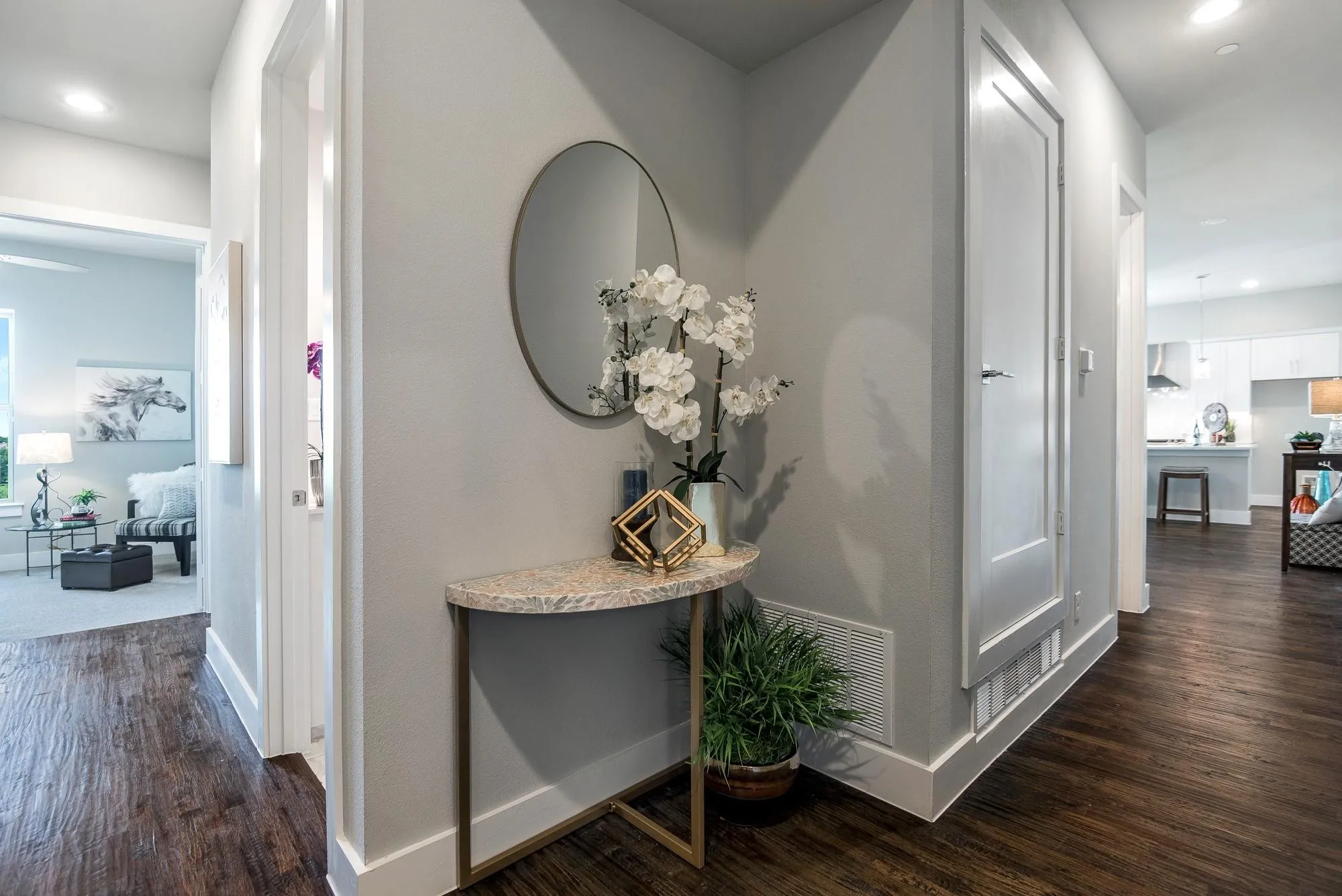 Hallway featuring dark wood flooring, light grey walls, and white baseboards