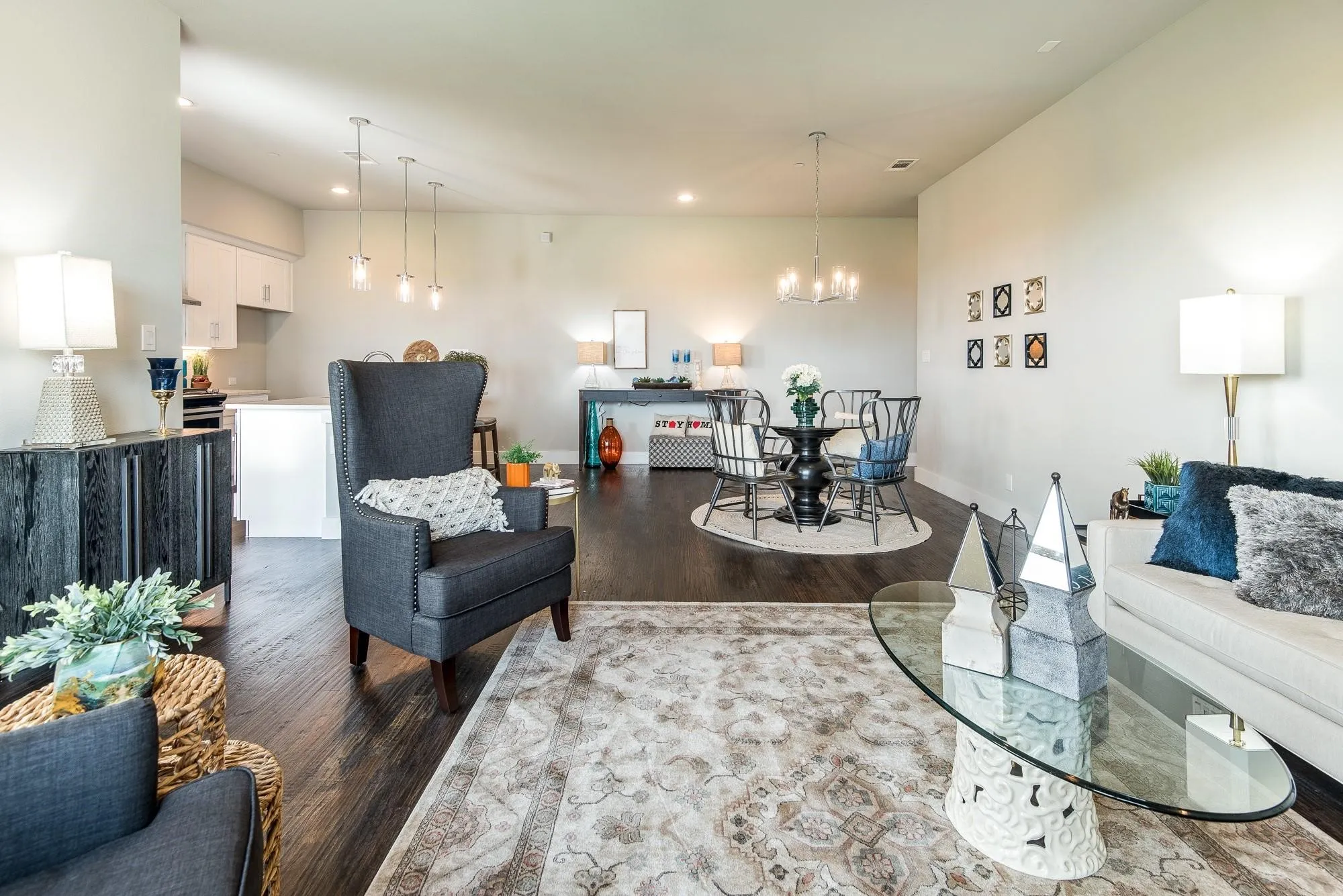 Open concept living area featuring dark wood flooring, light-colored walls, and various lighting fixtures