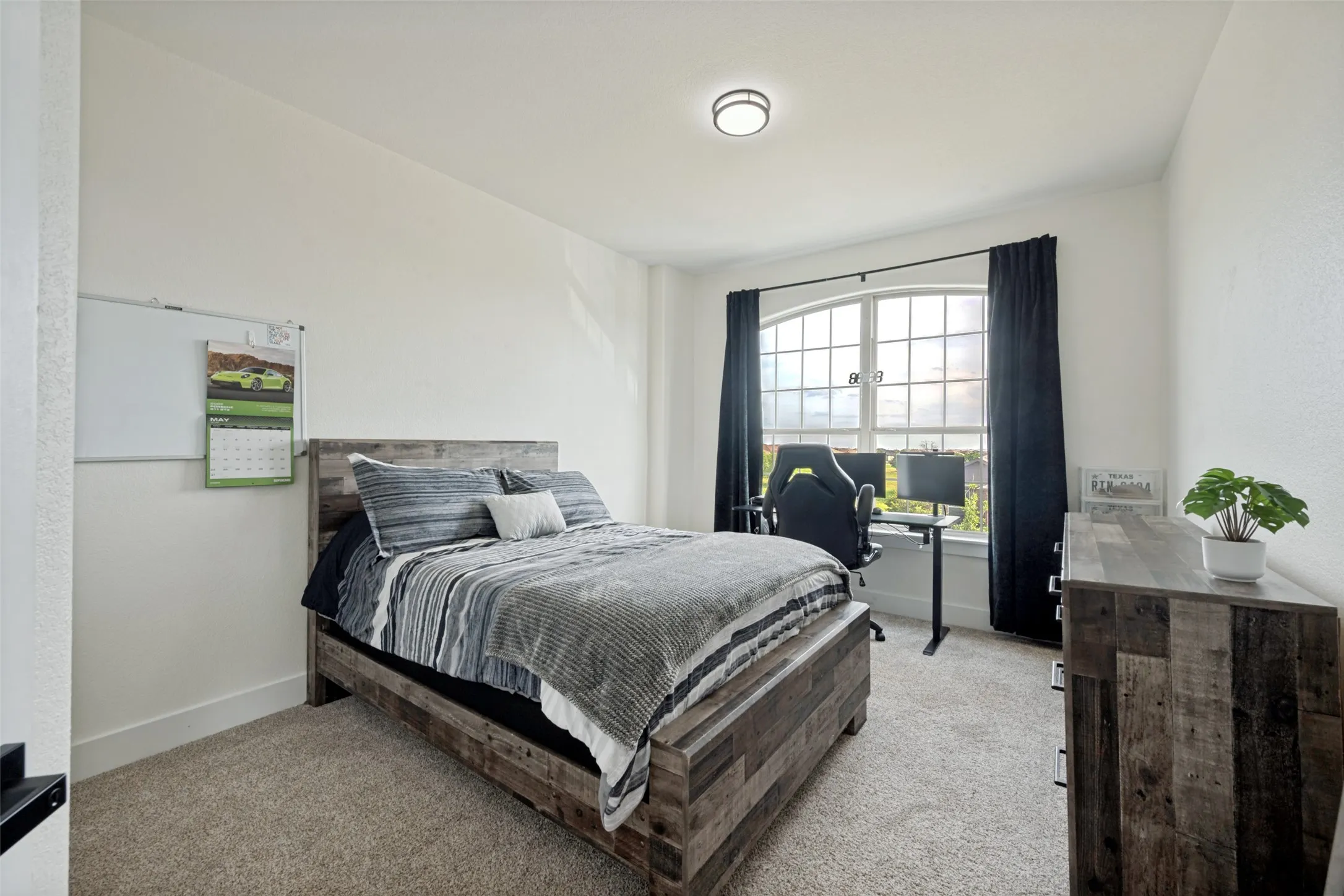 Carpeted room with a large arched window, recessed lighting, and white walls
