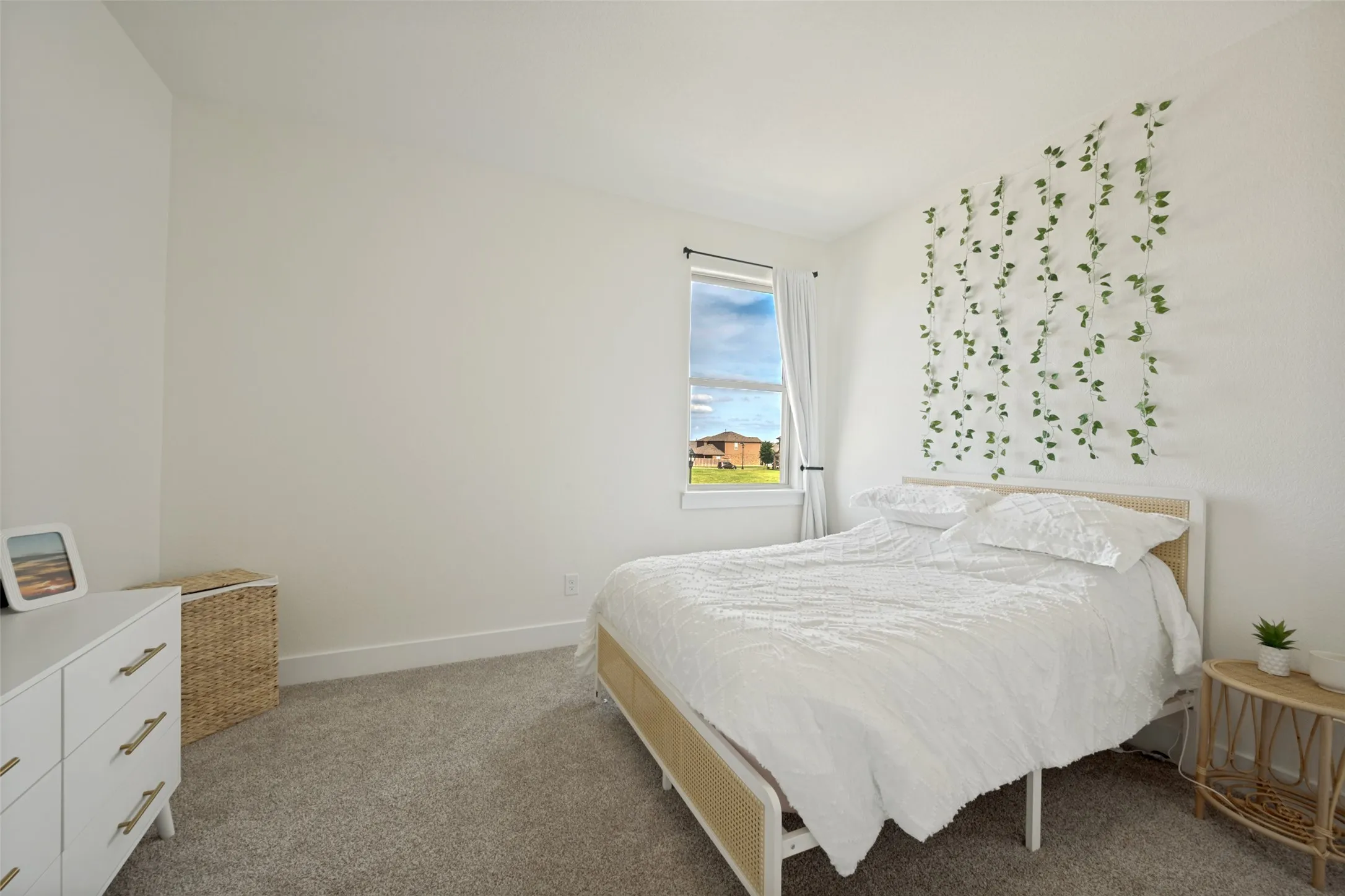 Carpeted room featuring a single window with white curtains, white walls, and white trim