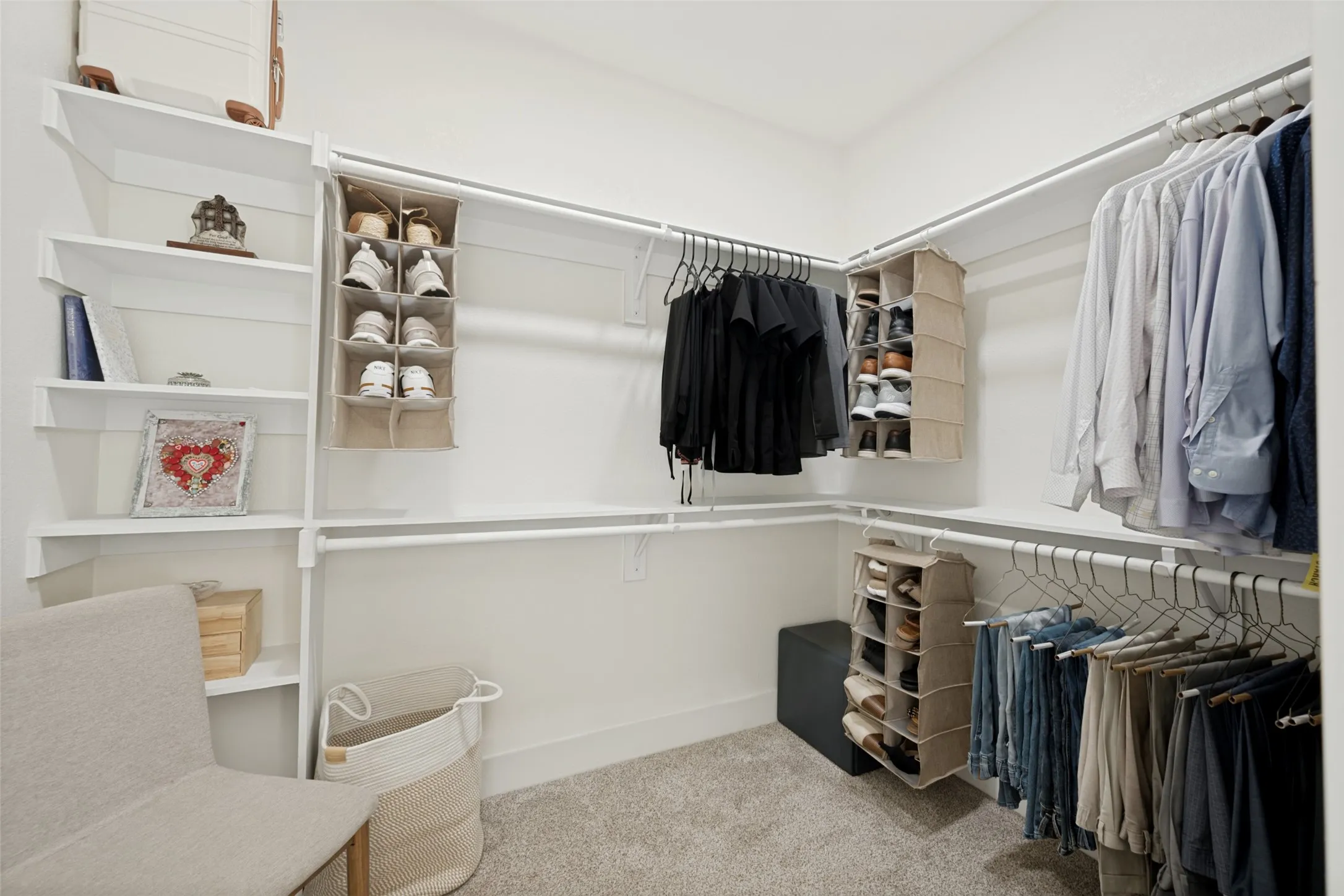 Walk-in closet in primary room featuring built-in shelving, multiple hanging rods, corner storage solutions, and carpet flooring