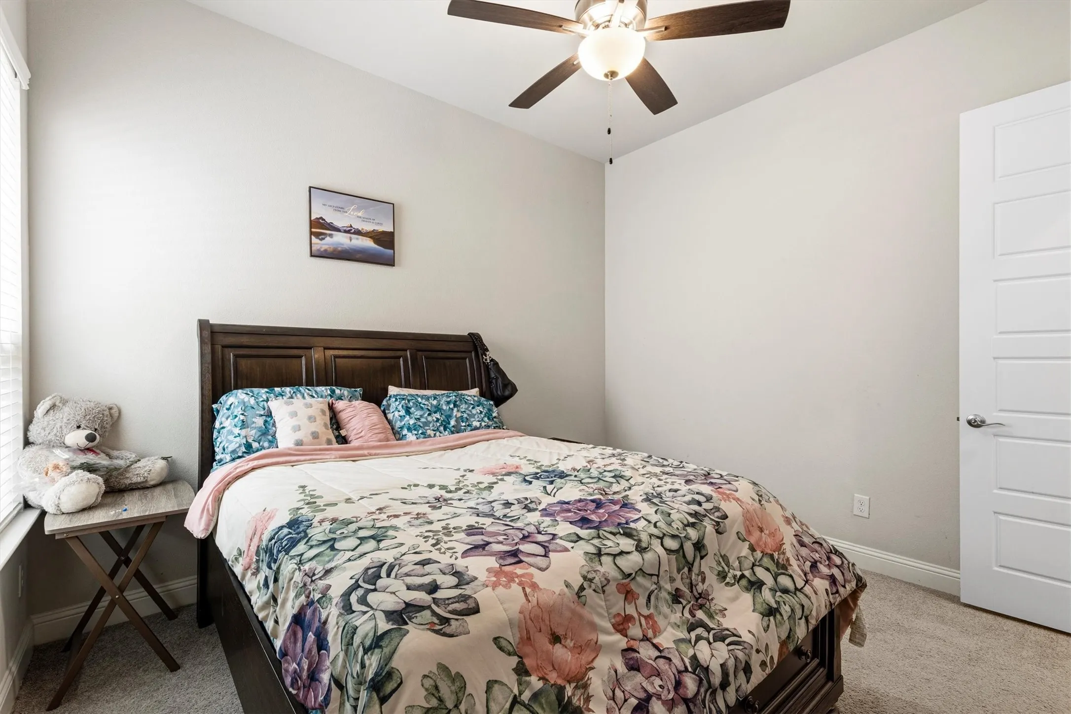 Carpeted bedroom featuring neutral wall tones and a ceiling fan with integrated lighting