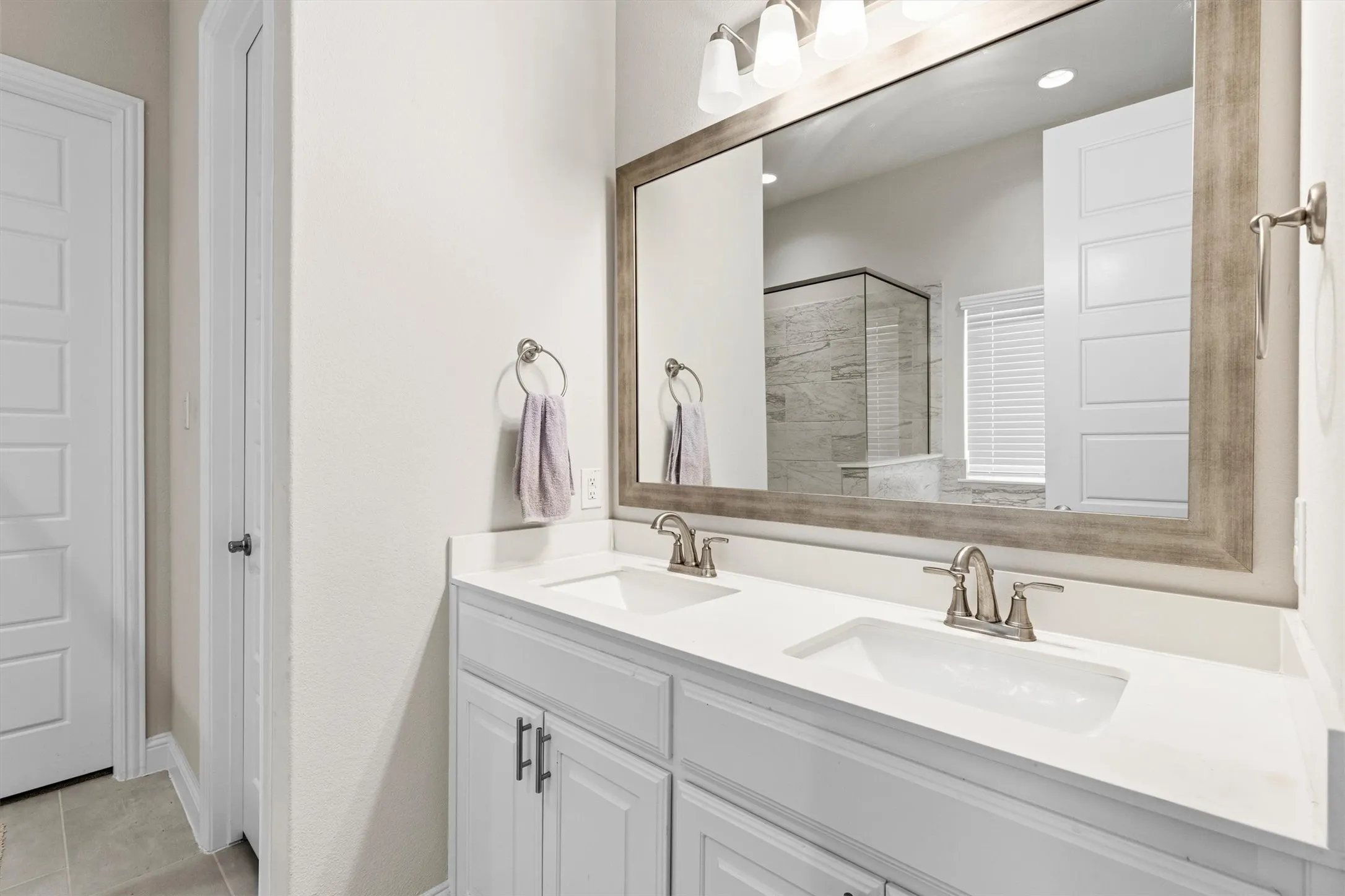 Double vanity featuring two undermount sinks, brushed nickel fixtures, and a white countertop