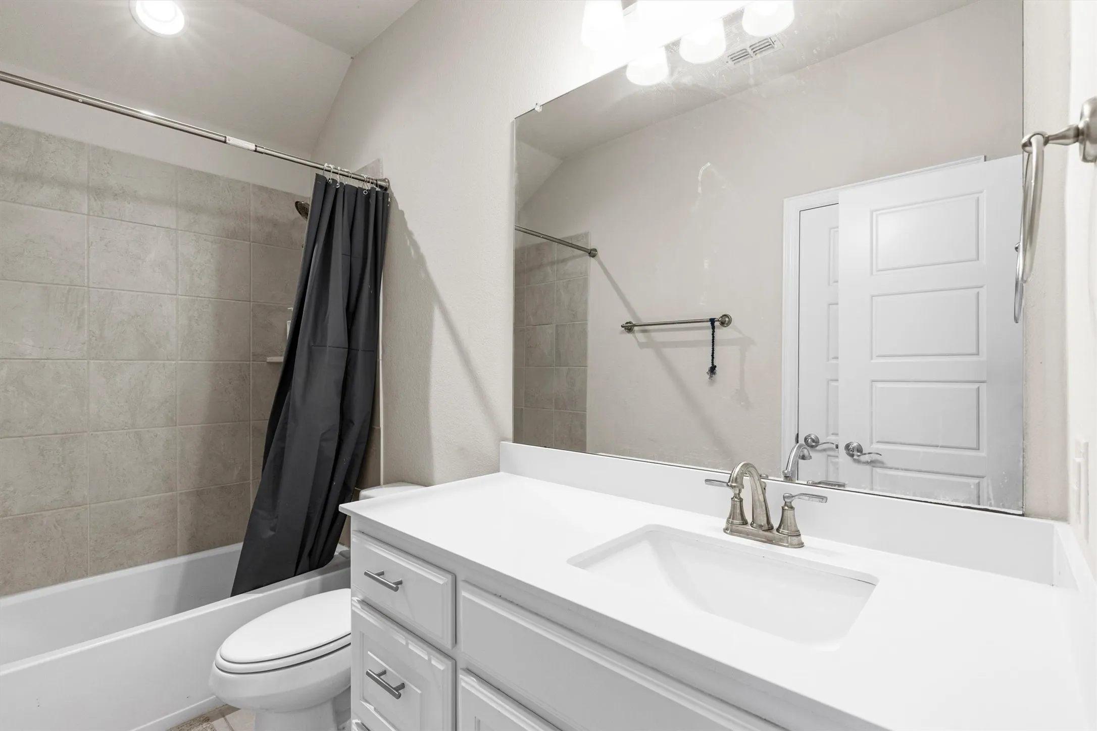Bathroom featuring a vanity with an integrated sink, brushed nickel faucet, and a wall-mounted mirror