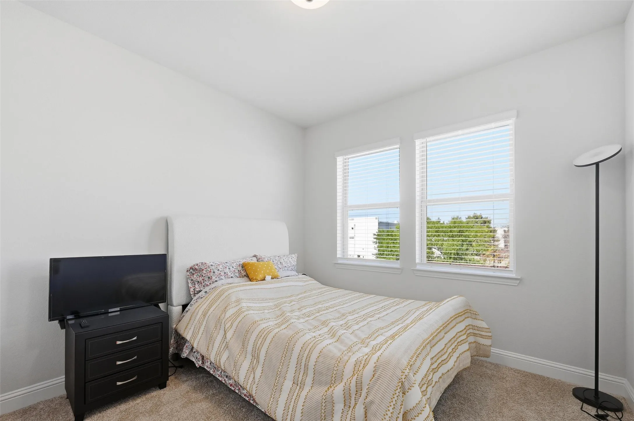 Bedroom featuring baseboards and light colored carpet