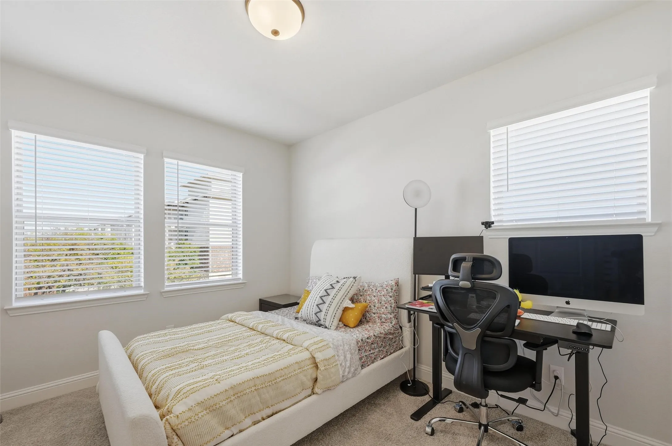 Carpeted bedroom featuring baseboards and an office area