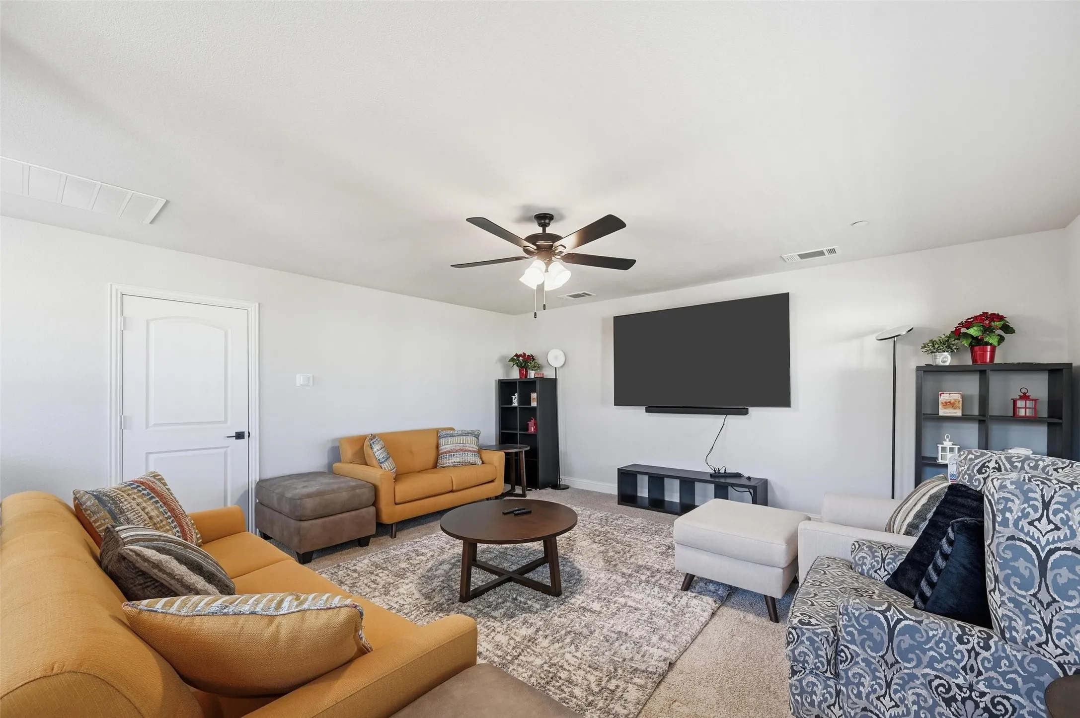 Carpeted living area with ceiling fan- 3rd floor