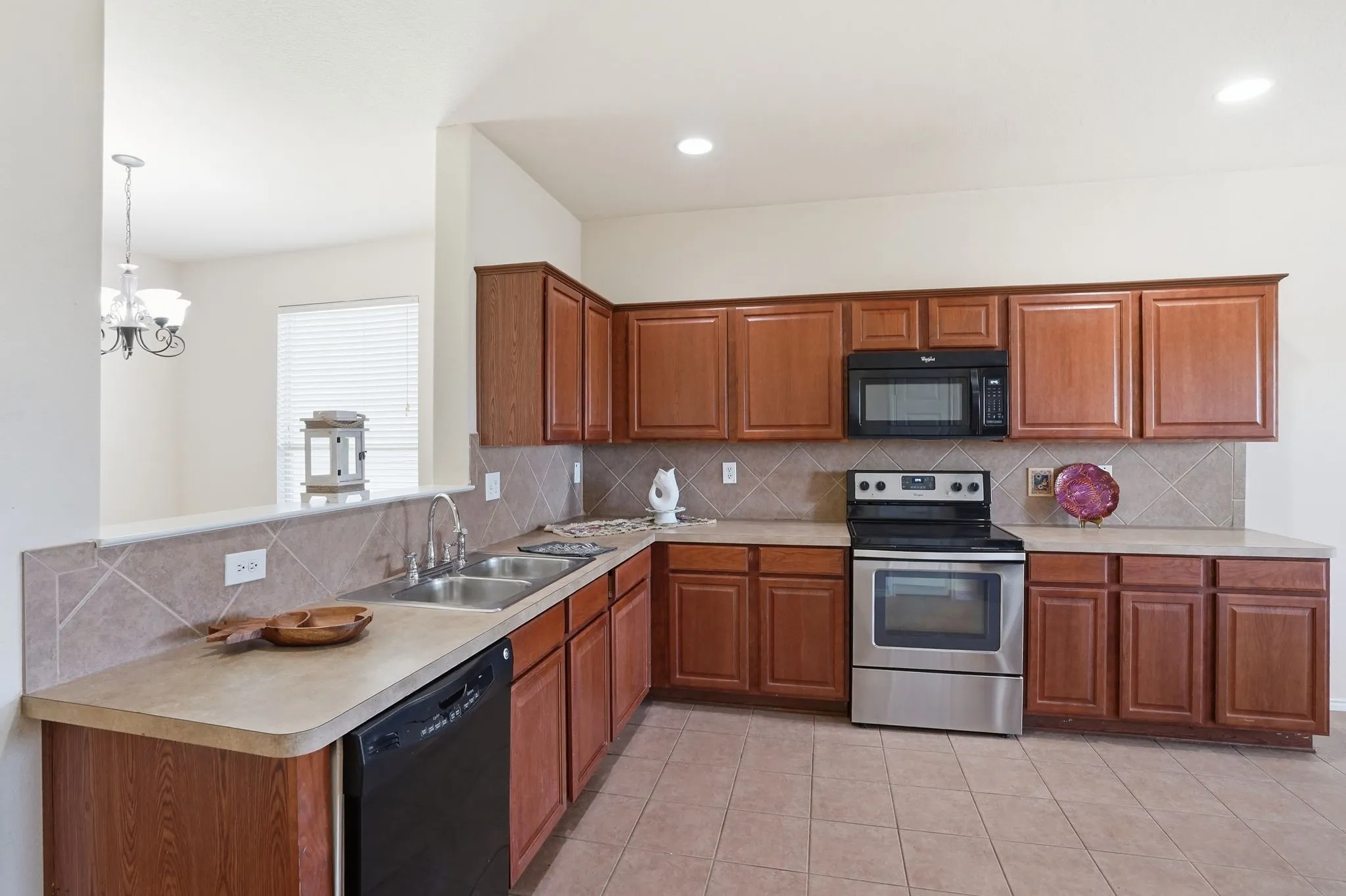 Kitchen featuring wood cabinetry, stone-look countertops, and a tiled backsplash