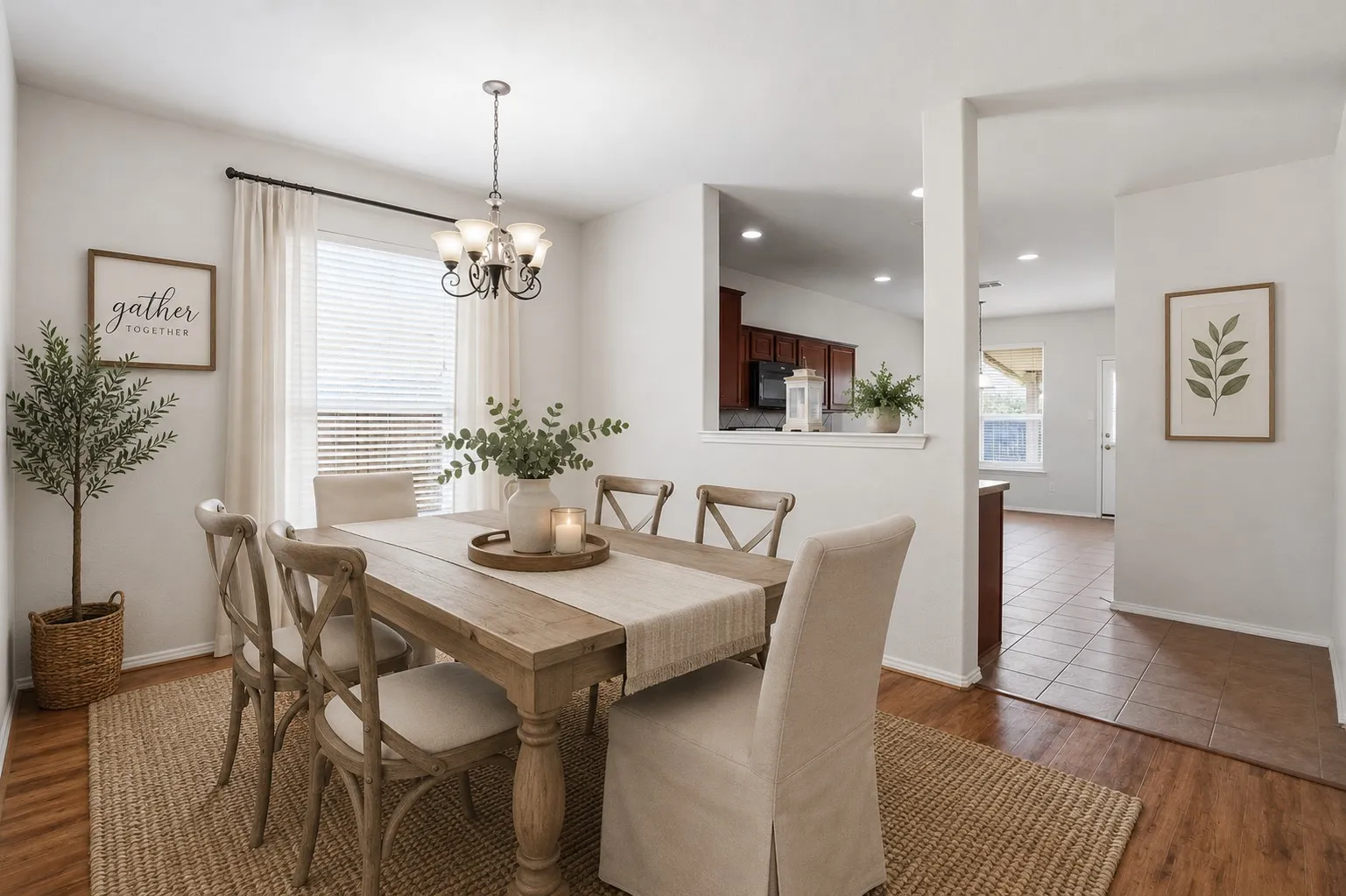 Virtually staged Dining space featuring a rectangular wood-finish table, a dark bronze chandelier, and wood-finish flooring