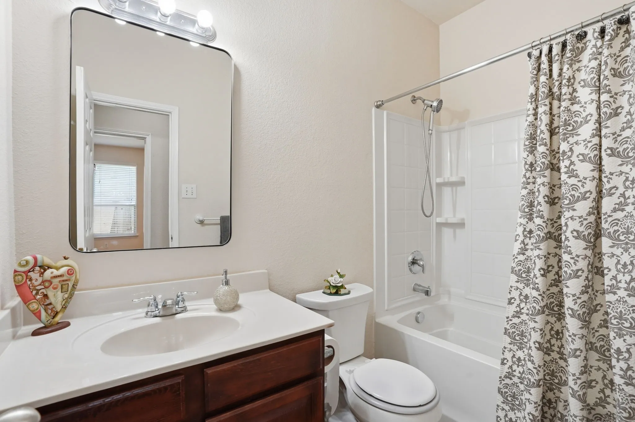 Bathroom featuring a vanity with a white countertop, chrome faucet, and a large rectangular mirror