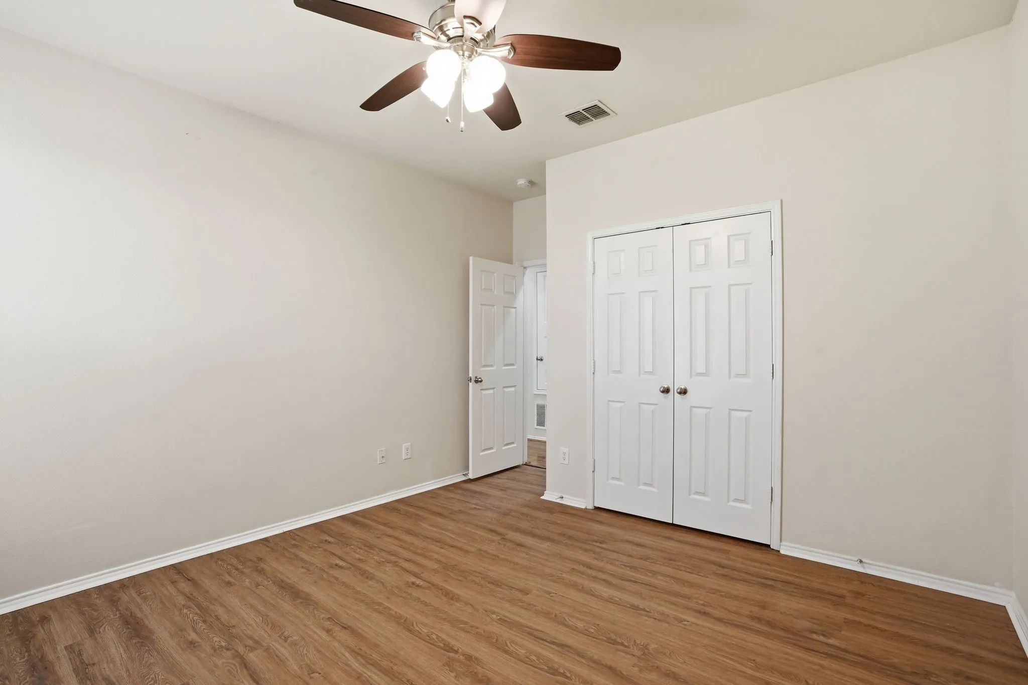 Neutral wall tones complemented by wood-finish flooring