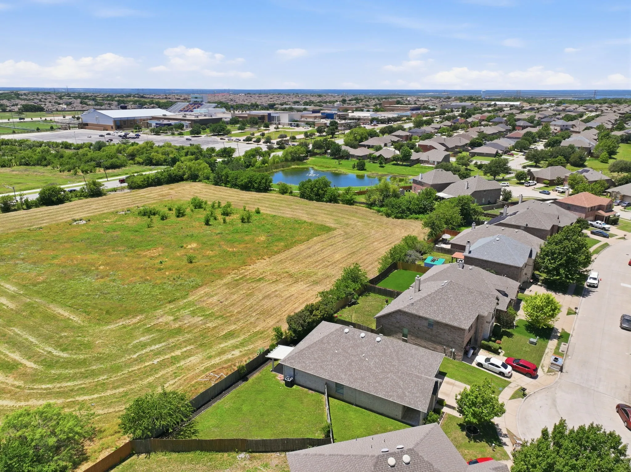 Aerial perspective showcasing a residential area with varied rooflines and surrounding green spaces