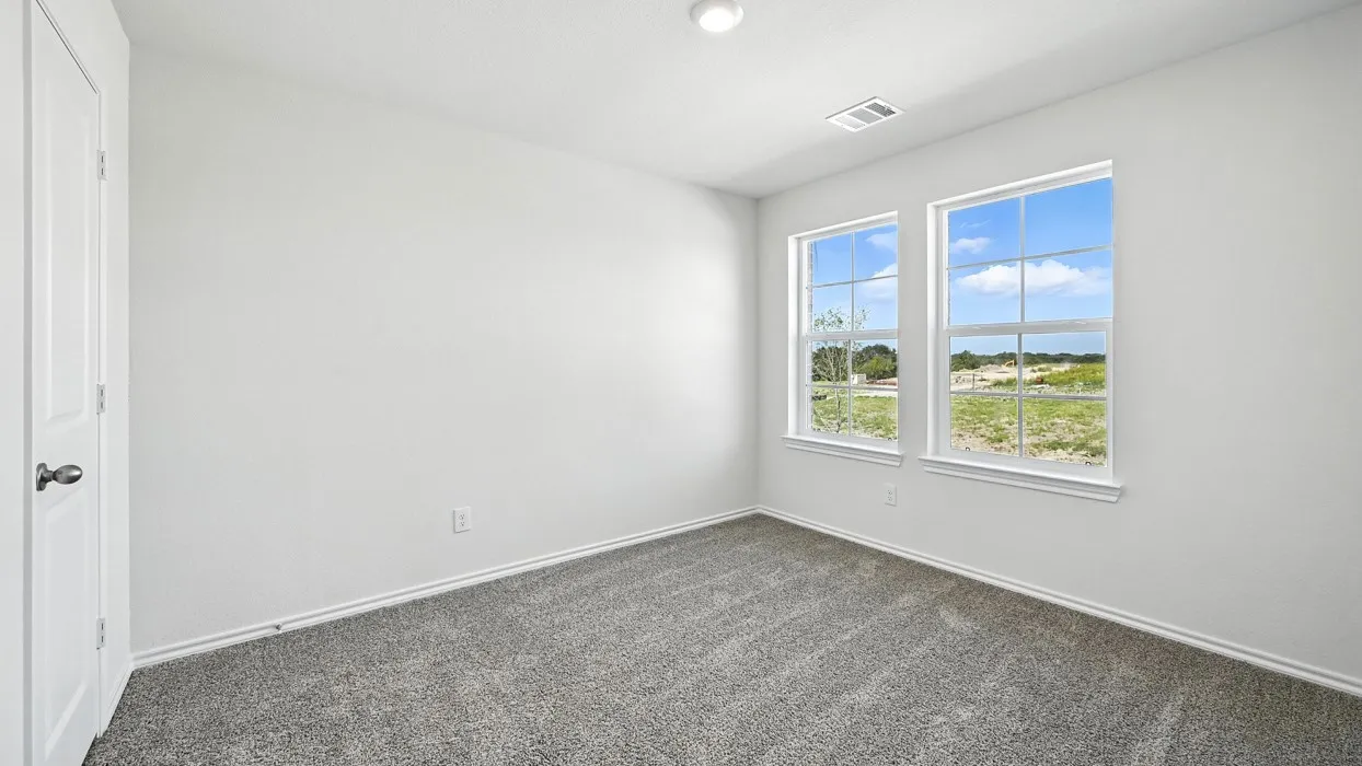 Room featuring two double-hung windows, a white paneled door, gray carpet, white baseboards, and a flush-mount ceiling light