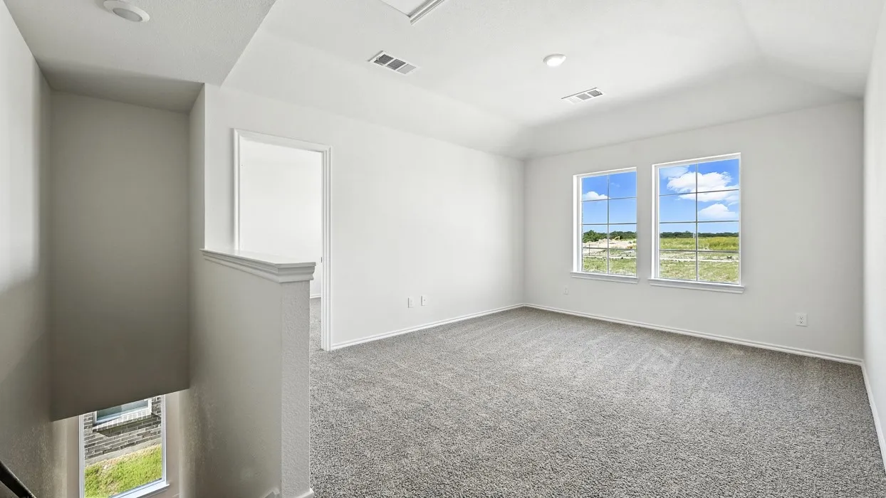 Spacious upper-level room featuring two prominent windows, plush gray carpeting, and recessed lighting