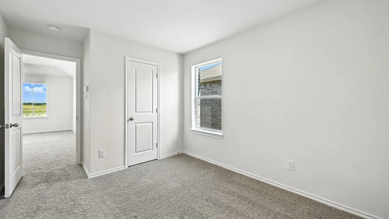 Carpeted room featuring white walls, white trim, and a window providing natural light