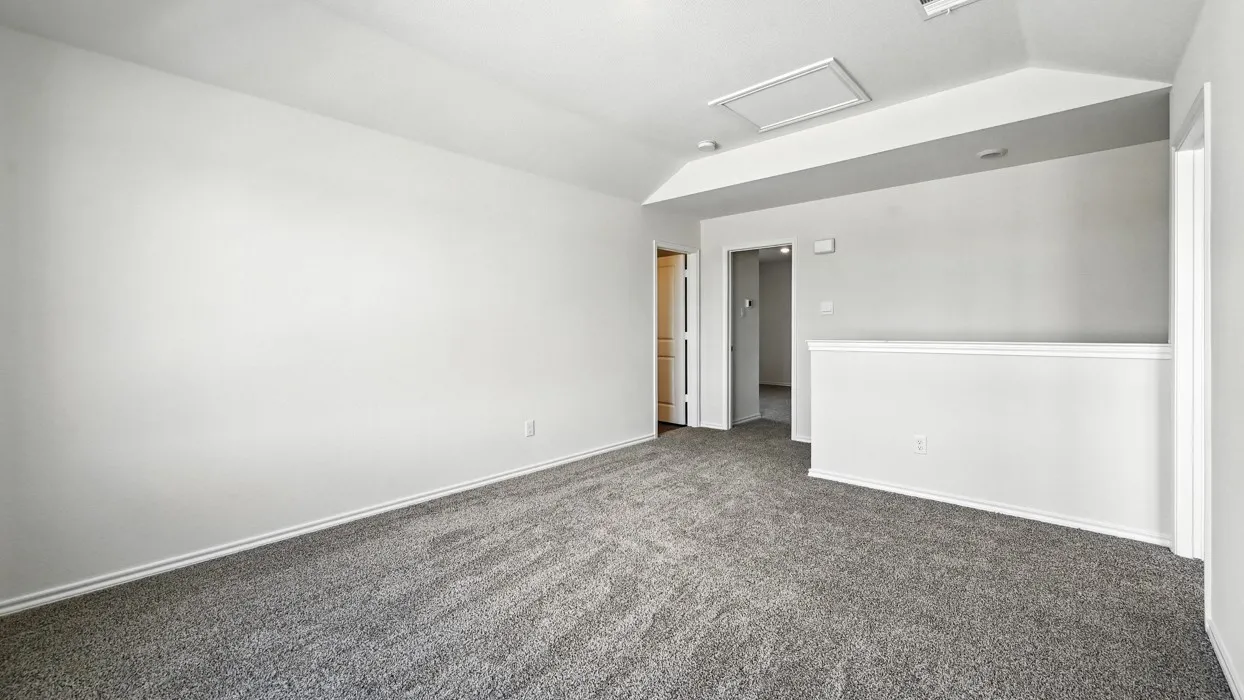 Spacious room featuring neutral carpeting, light-colored walls, and a white ceiling