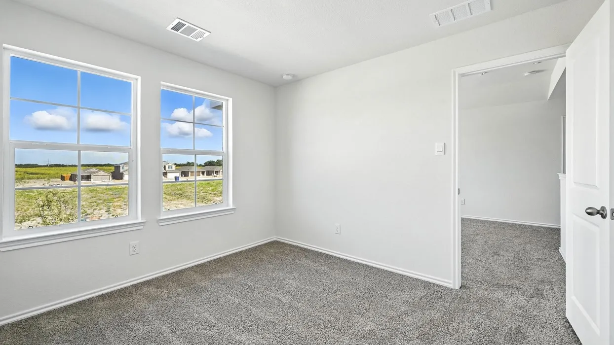 Bright room featuring two large windows with white trim, soft gray carpet, white walls, recessed lighting, and a white interior door with black hardware