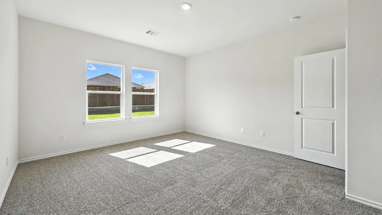 Spacious room with plush gray carpet, bright white walls, two large windows, a two-panel interior door, and recessed lighting