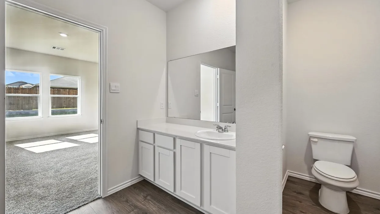 Bathroom vanity area featuring white cabinetry, a single basin sink, and a large wall-mounted mirror