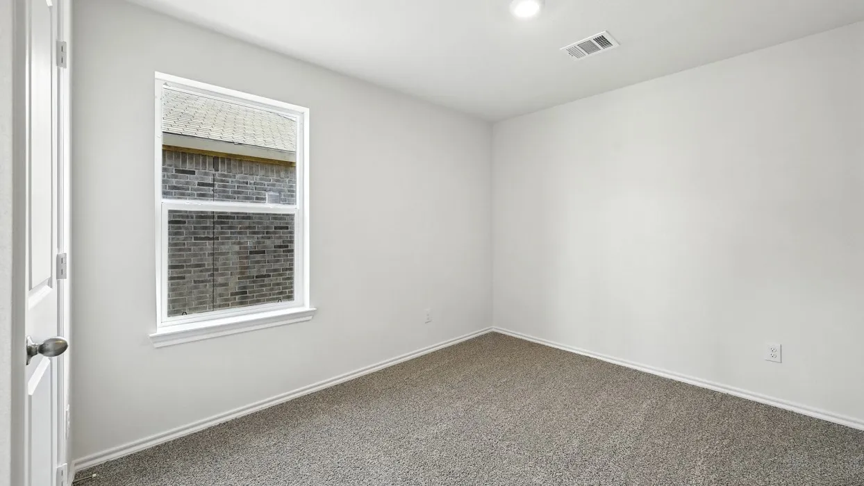 Interior room featuring neutral wall paint, carpet flooring, a single window, and a ceiling-mounted light fixture
