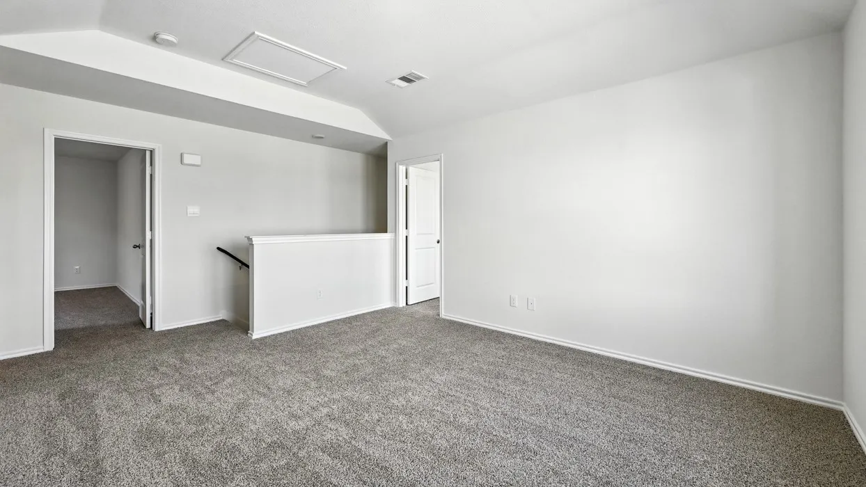 Spacious upper-level room featuring neutral gray carpeting and white painted walls