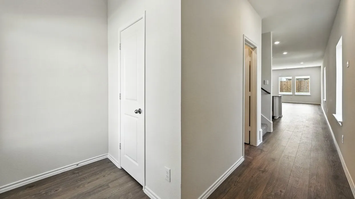 Hallway featuring wood-finish flooring, recessed lighting, and white baseboards