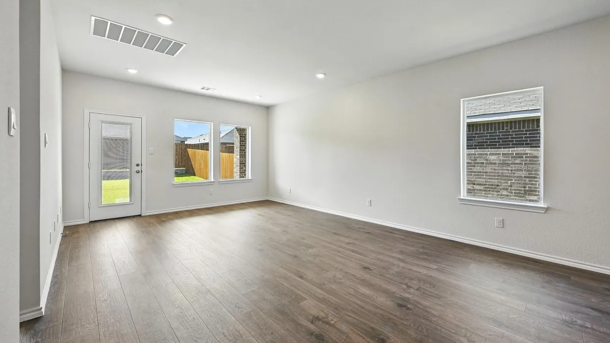 Spacious room featuring wood-finish flooring, white walls, and recessed lighting