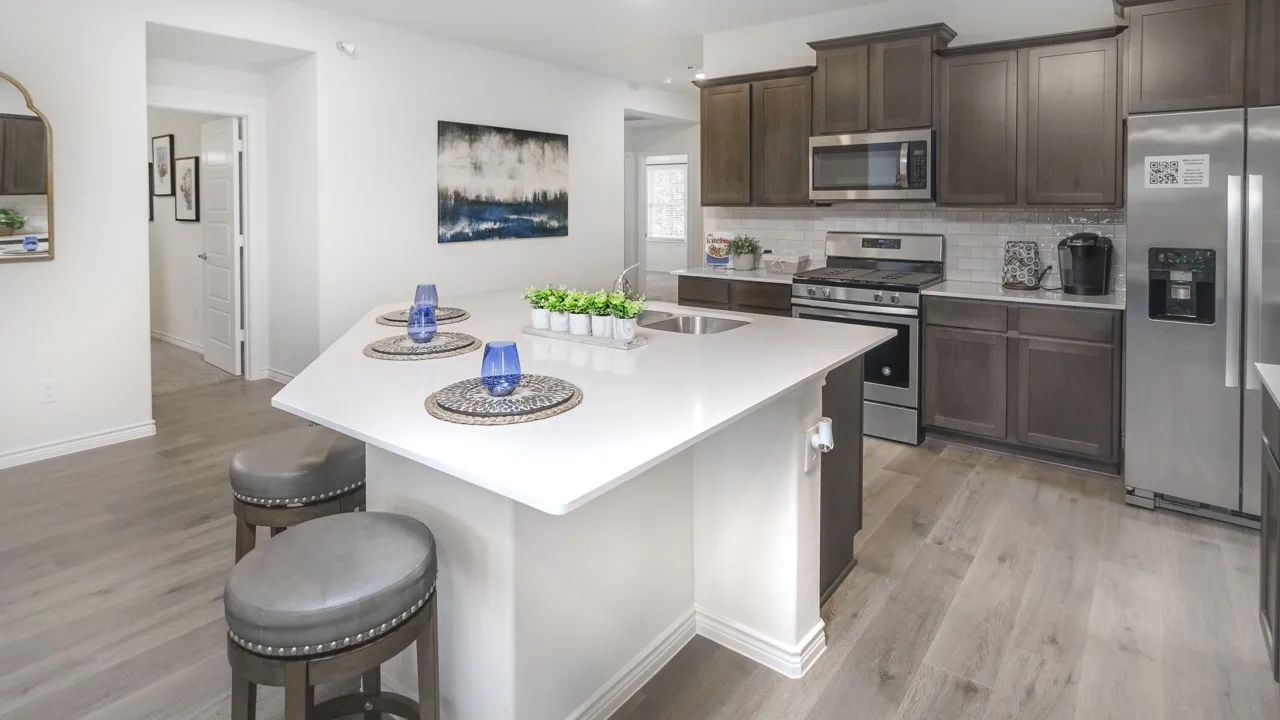 Modern kitchen featuring an angled island with a solid surface countertop and undermount sink