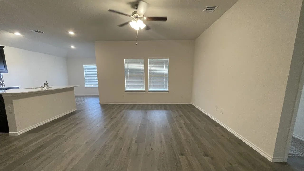 Open-concept living area featuring wood-finish flooring, recessed lighting, and a ceiling fan