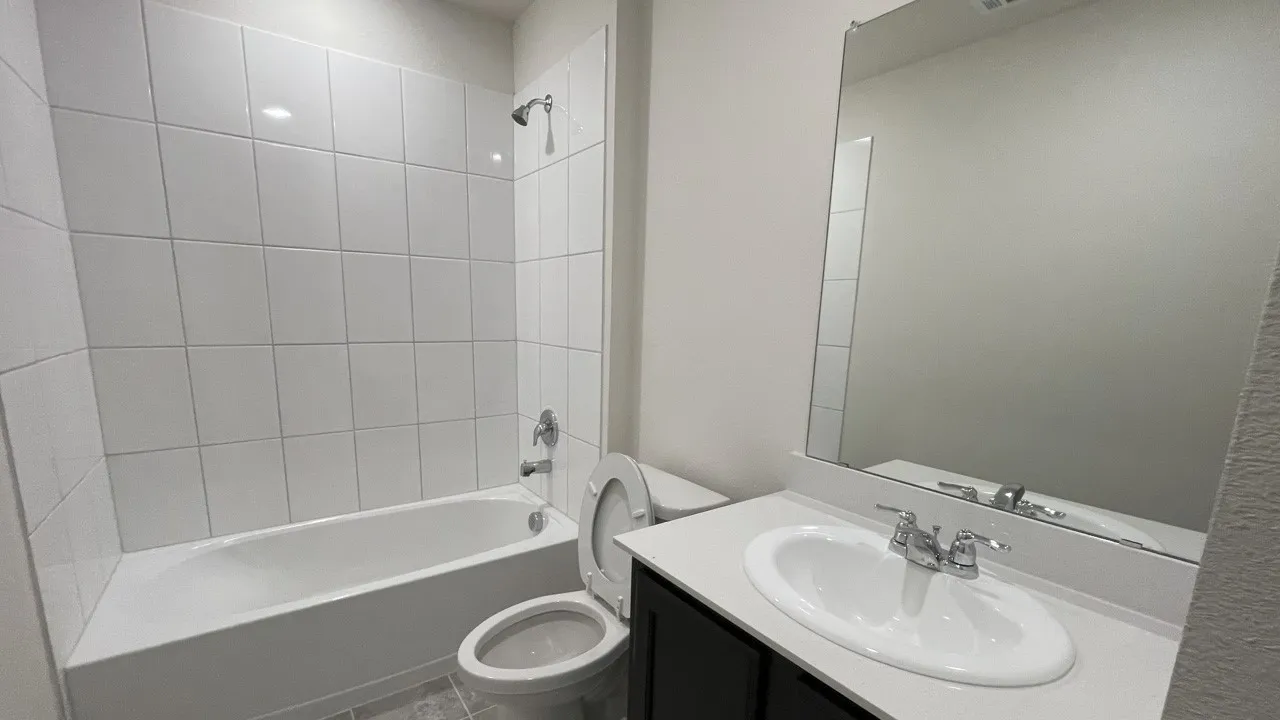 Full bathroom featuring a white porcelain bathtub, chrome shower fixtures, and white subway tile surround