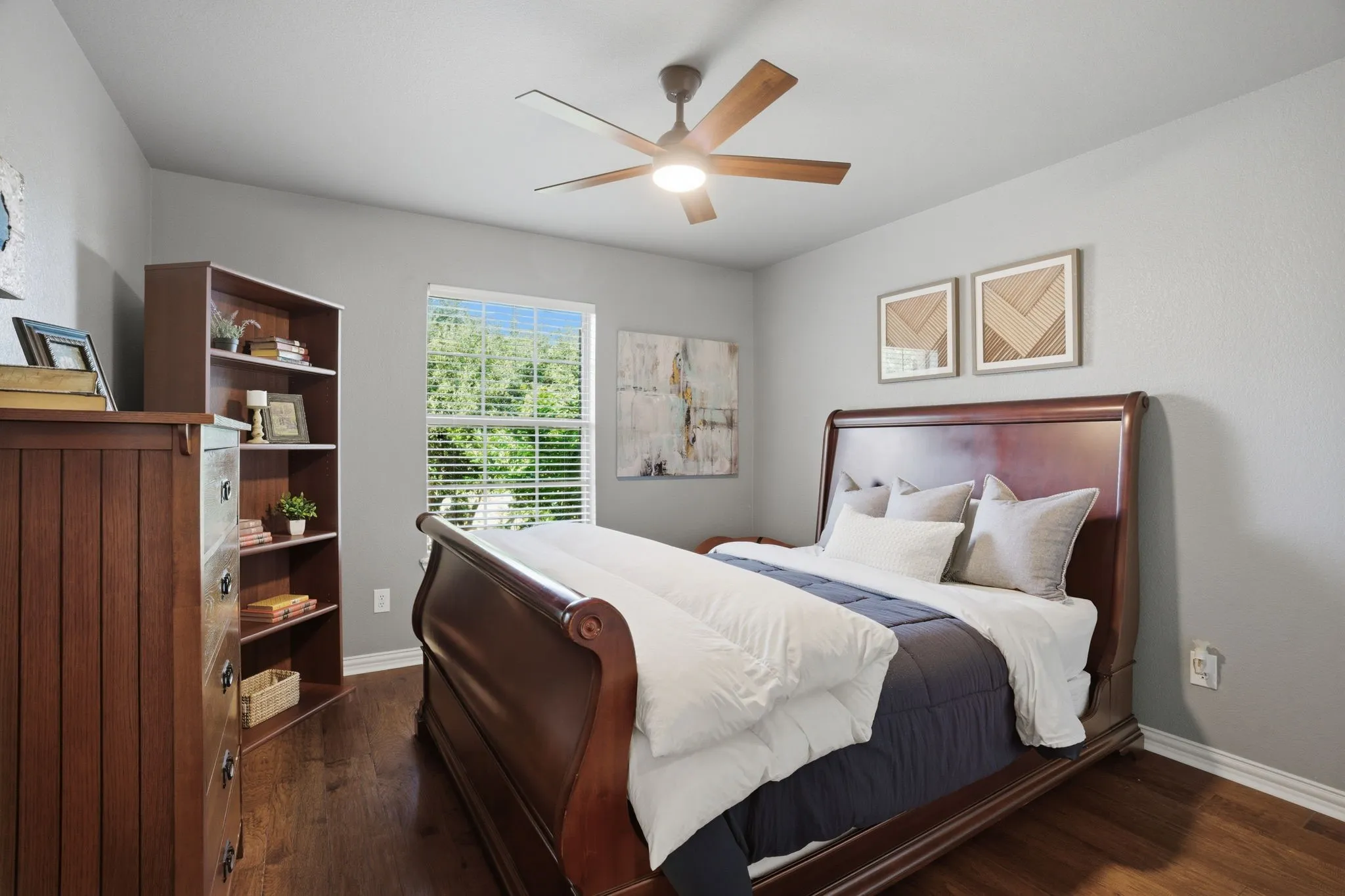 Bedroom 4 features wood flooring, front yard views, and a ceiling fan for added comfort. A spacious closet, accessed through elegant French doors, includes built-in shelving for enhanced organization.
