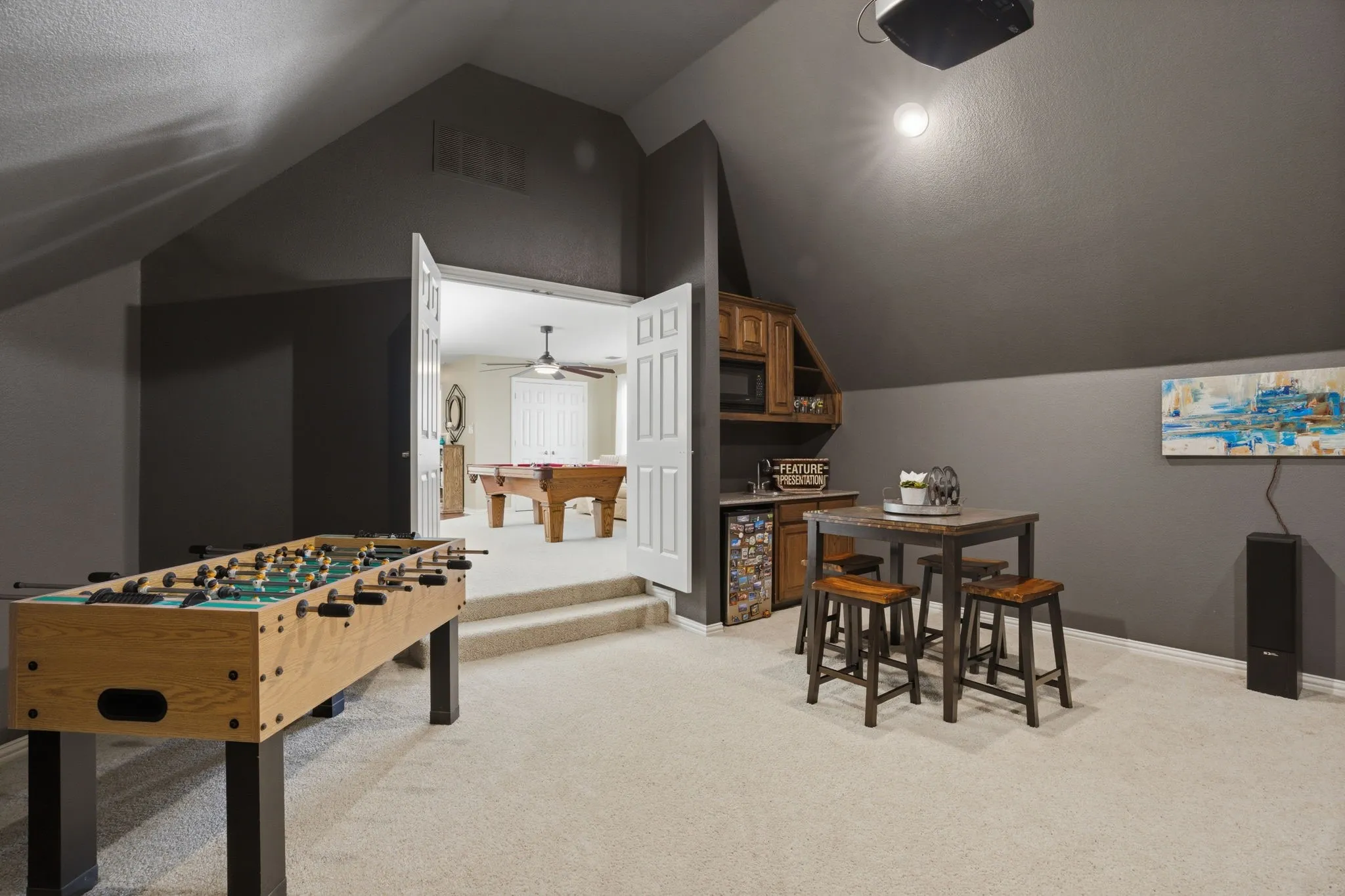 A wet bar in the media room comes with built-in cabinetry, granite countertops with a sink, and a built-in microwave completes the setup, creating the perfect space for movie nights with popcorn and snacks.
