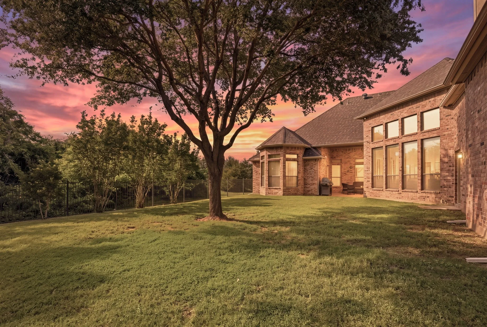 The private and spacious back yard is blanketed with green grass, numerous trees, and a metal fence allowing for serene greenbelt/park views along the west side of the home.
