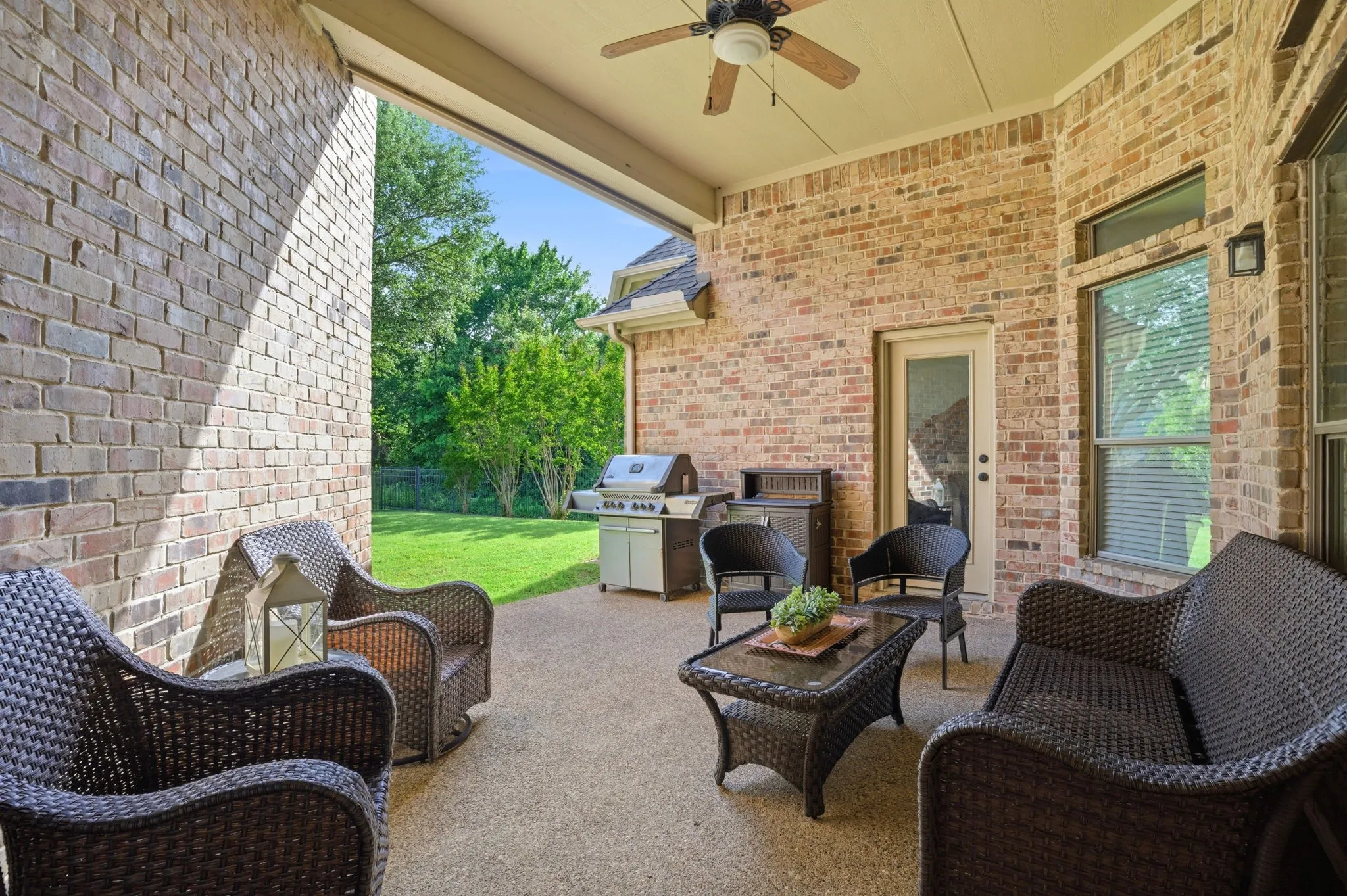 A glass exterior door opens to the covered back porch, seamlessly extending the living space for an effortless indoor-outdoor experience. The porch features a ceiling fan for added comfort and an additional exterior door providing private access directly from the primary suite.