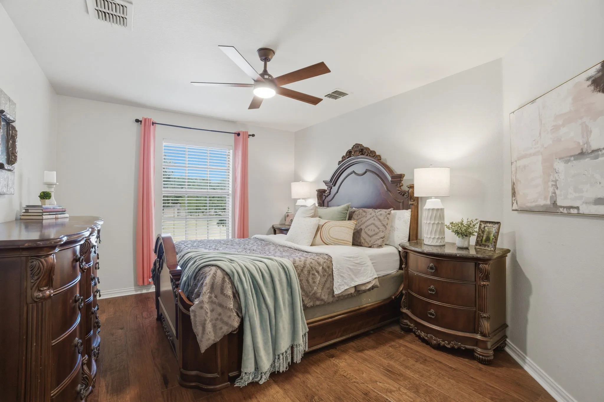 Bedroom 3, located on the second floor, features wood flooring, a window overlooking the front yard, and a ceiling fan for year-round comfort. An extended walk-in closet provides exceptional storage space.
