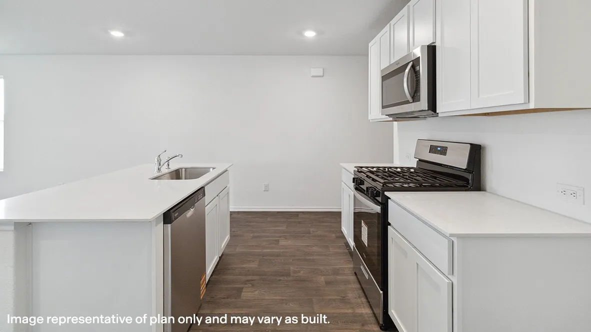 Modern kitchen featuring white cabinetry, light-toned countertops, stainless steel appliances including a built-in microwave and gas range, and wood-finish flooring