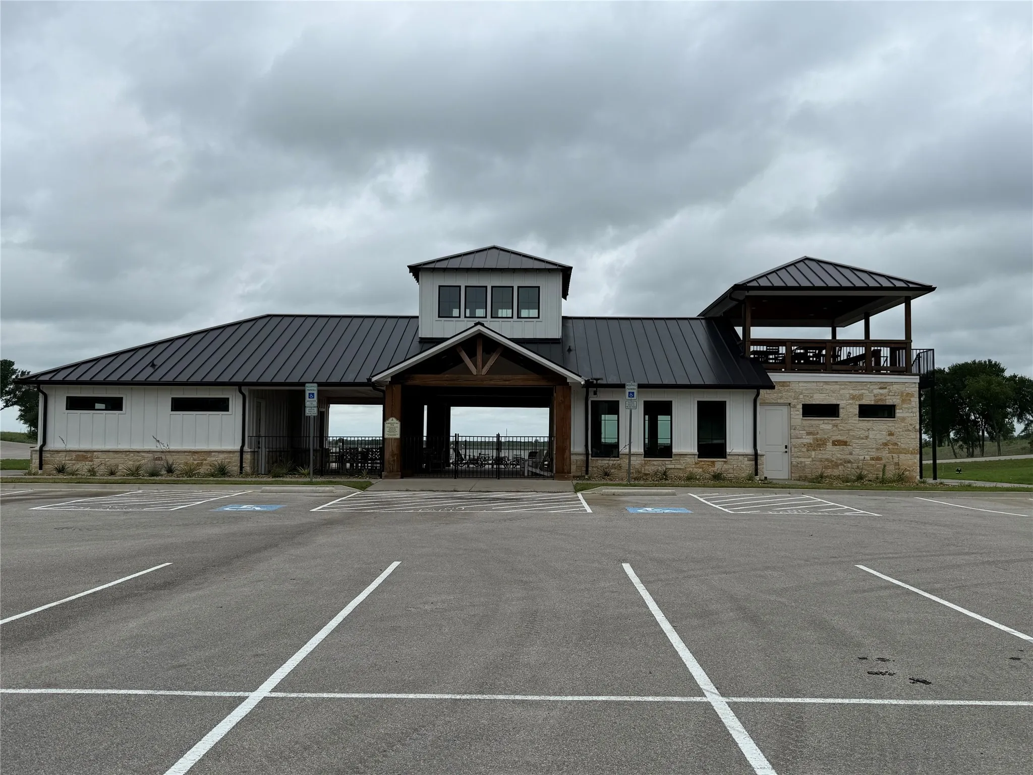 Modern exterior with white siding, stone accents, and a dark metal roof
