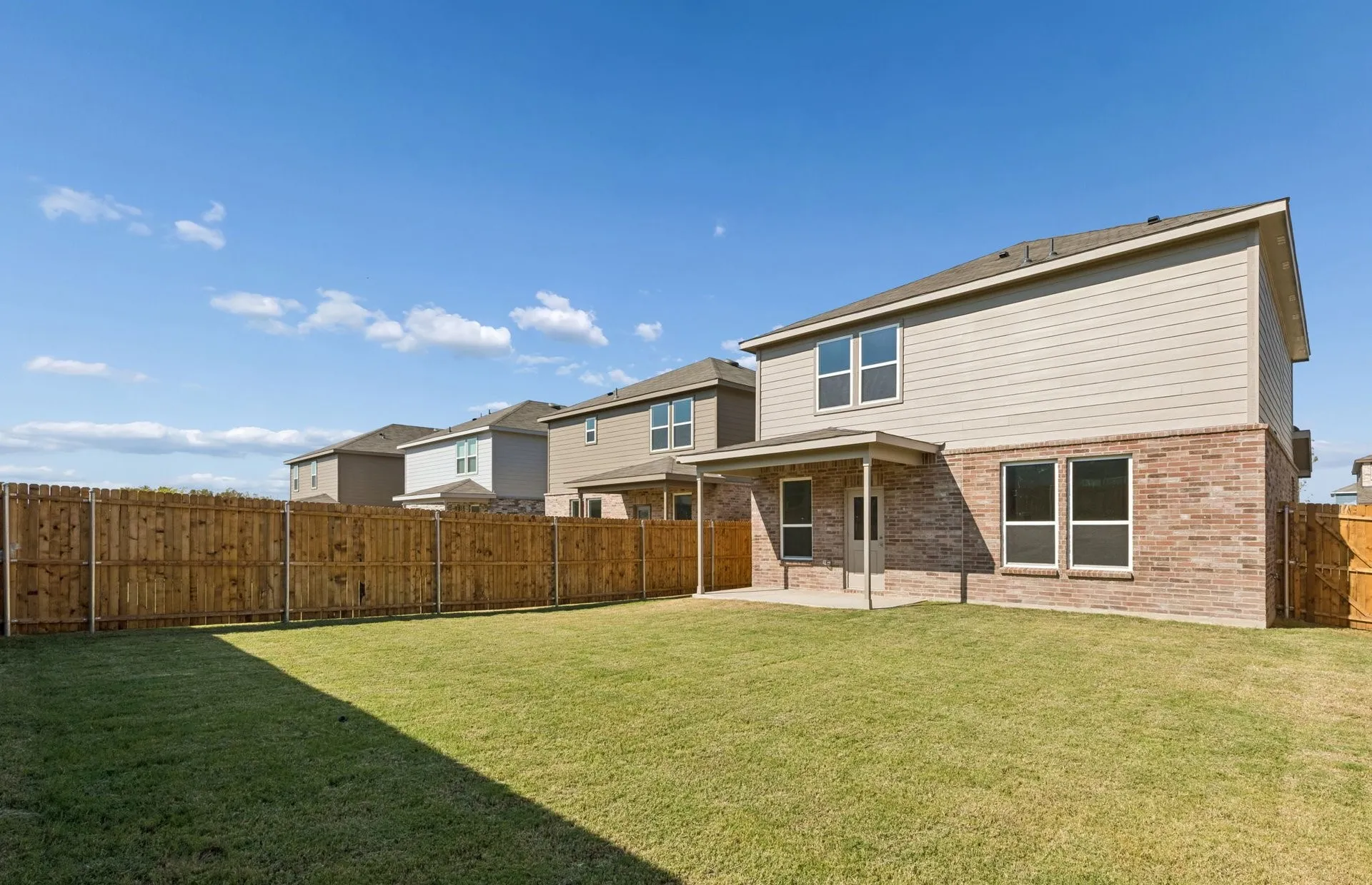 Oversized fenced-in backyard with a covered patio