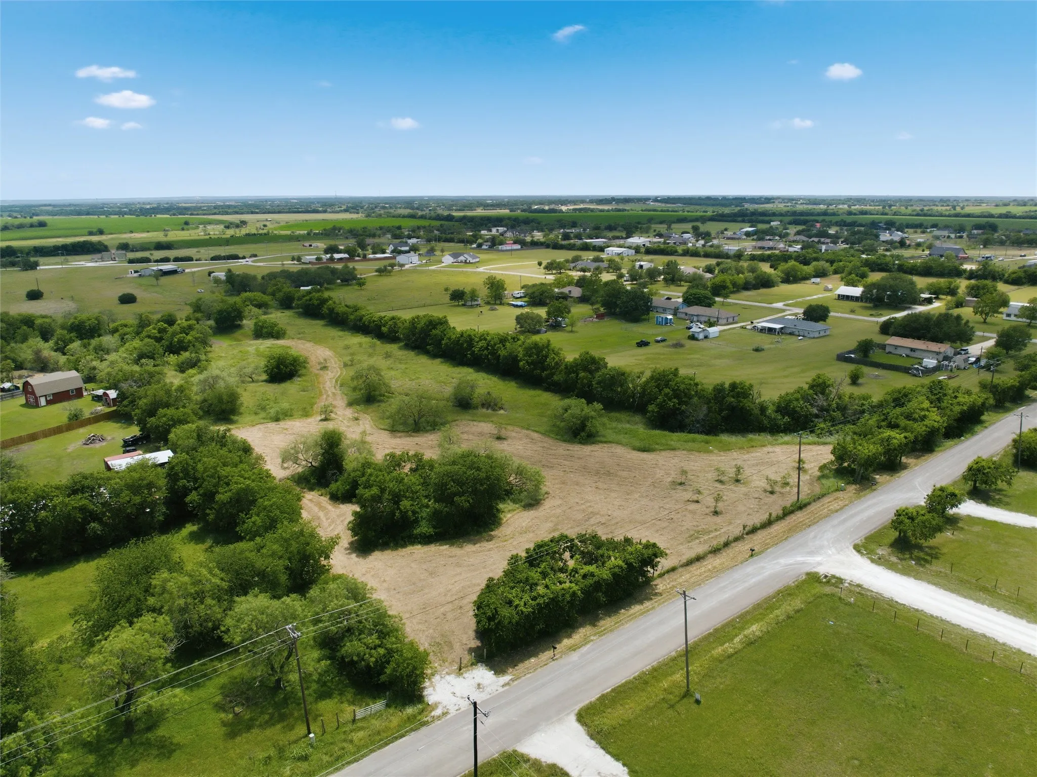 Expansive rural landscape featuring a mix of open fields and scattered trees