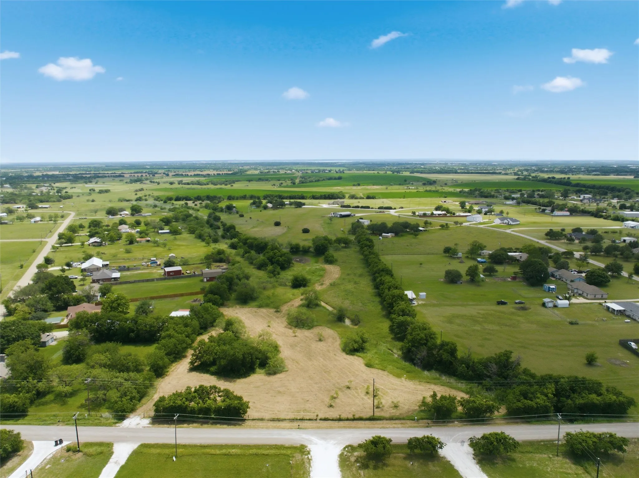 Expansive undeveloped land parcel featuring scattered trees and a clear perimeter