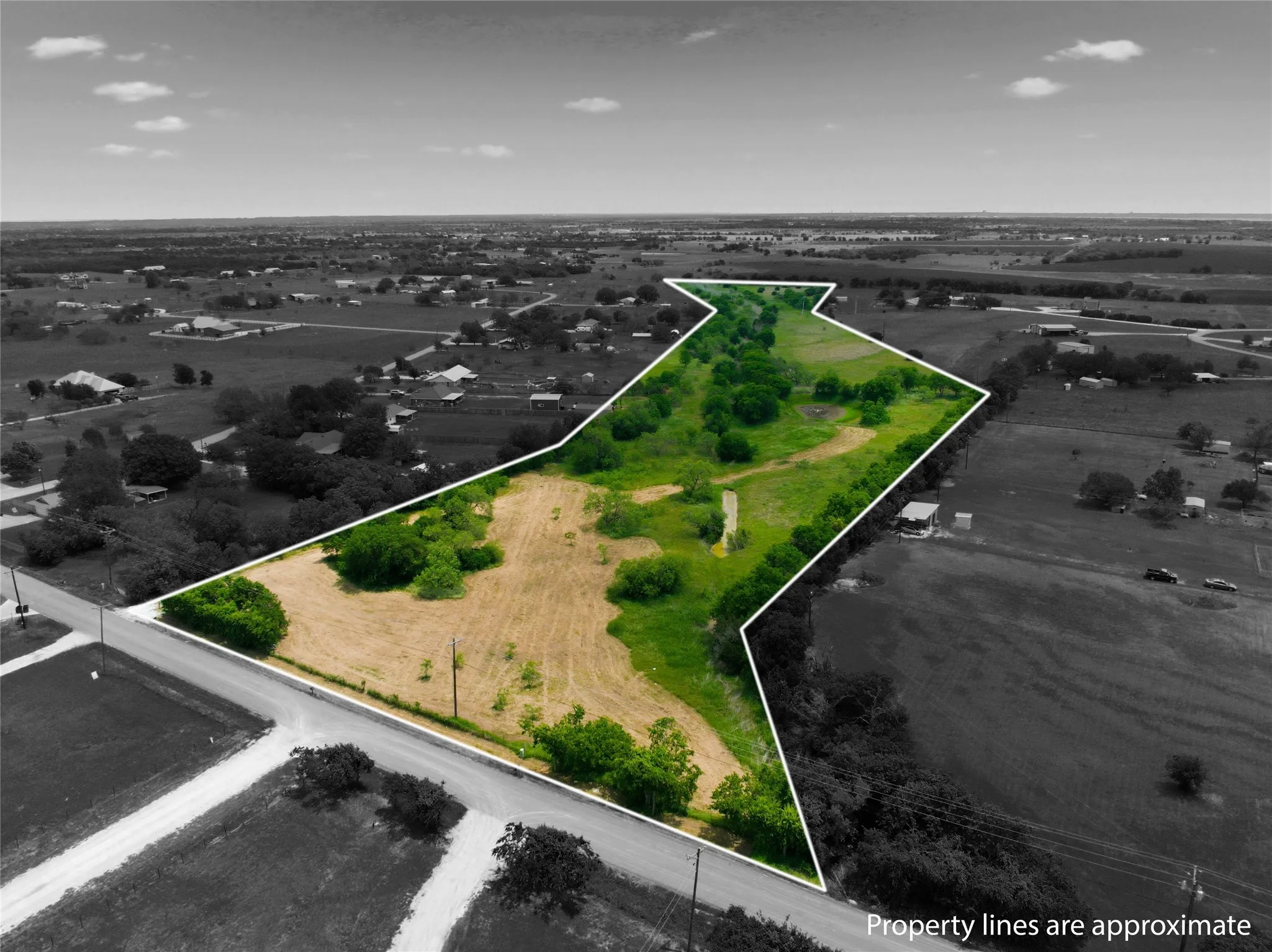 Expansive land parcel featuring varied terrain, including open fields and natural tree cover