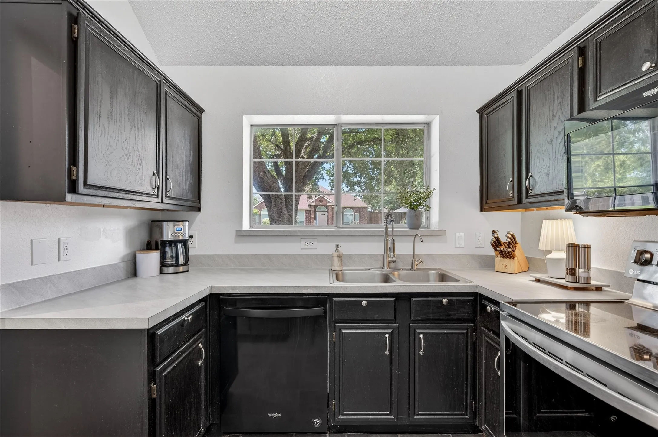 Black dishwasher and views of the front yard