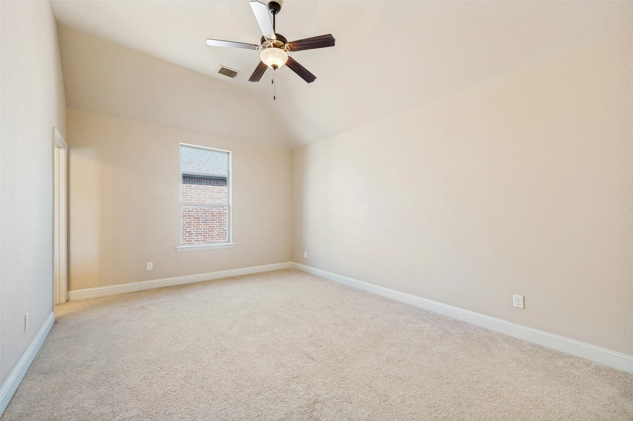Spacious secondary bedroom with soaring vaulted ceilings, plush carpet, and abundant natural light, creating a bright and inviting retreat. Complete with a private ensuite bathroom and walk-in closet, this well-appointed suite offers comfort, privacy, and flexibility for family members or overnight guests.
