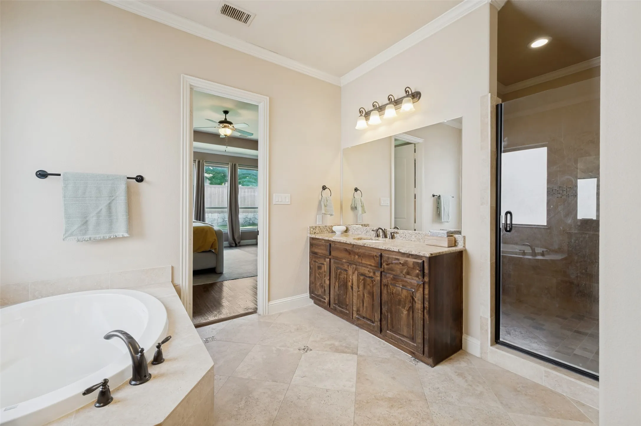 Luxurious primary ensuite featuring spacious dual sinks and vanities with granite countertops, an oversized walk-in shower with designer tile, and a relaxing soaking tub. Elegant finishes, abundant natural light, and a thoughtfully designed layout create a spa-like retreat you'll enjoy every day.