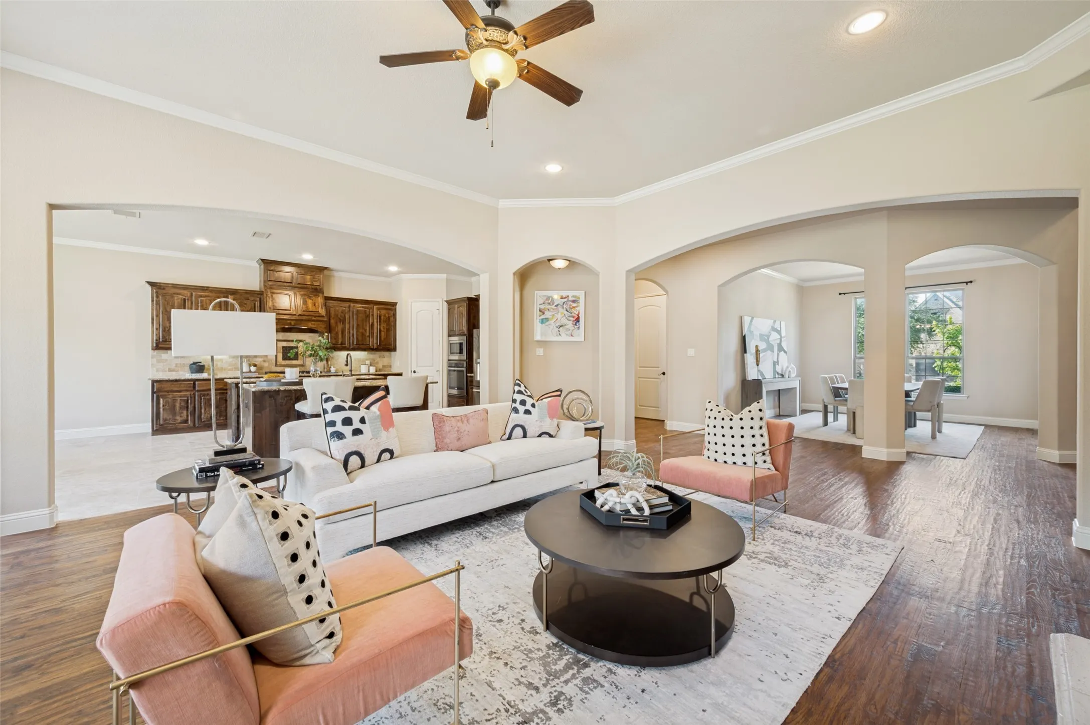 The heart of the home, this inviting great room blends timeless elegance with everyday comfort. Rich hardwood floors, soaring ceilings, graceful architectural arches, and abundant natural light create a warm, sophisticated atmosphere. Open to the chef's kitchen and dining spaces, this expansive living area is ideal for entertaining, relaxing, and making lasting memories with family and friends.