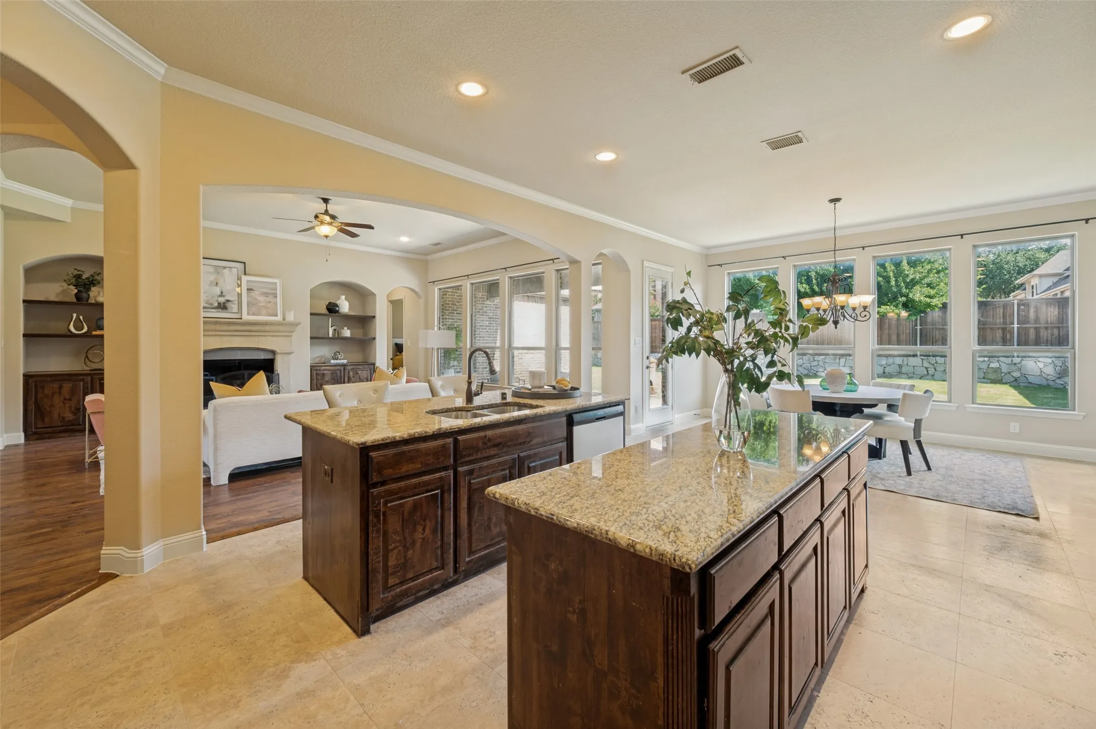 Designed for effortless entertaining, this spectacular open-concept kitchen and breakfast area flow seamlessly into the family room, creating the perfect gathering space. Dual oversized granite islands, rich custom cabinetry, stainless steel appliances, double ovens, and a gas cooktop offer exceptional style and function, while expansive windows fill the space with natural light and showcase serene backyard views.